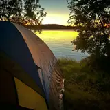A tent and campsite overlooking a sceneic lake