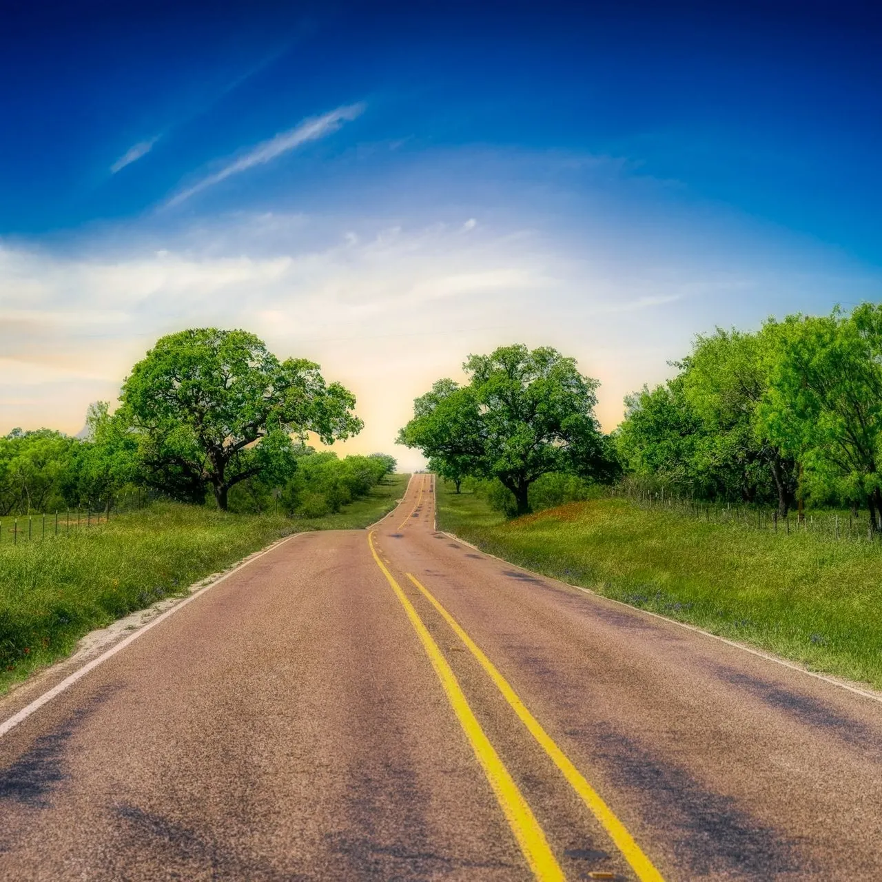 A winding back road through the rolling green hills of the Texas Hill Country near Dripping Springs