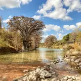 Autumn trees and foliage along the clear water of the Guadalupe River in Texas